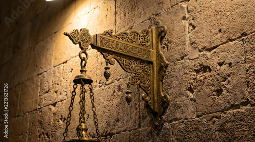 Ramadan decorative brass thurible and cross mounted on stone wall
