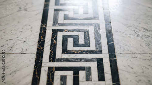 Geometric marble floor pattern with intricate black and white inlay