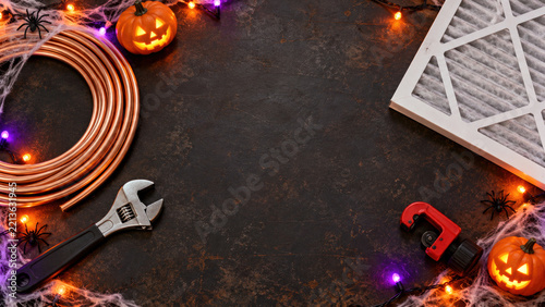 Copper pipe coil wrench pipe cutter and air filter with pumpkins flat lay - Halloween HVAC technician background