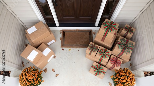 Wrapped christmas presents and delivery boxes sitting on house porch doorstep with holiday gifts package delivery front door christmas shopping