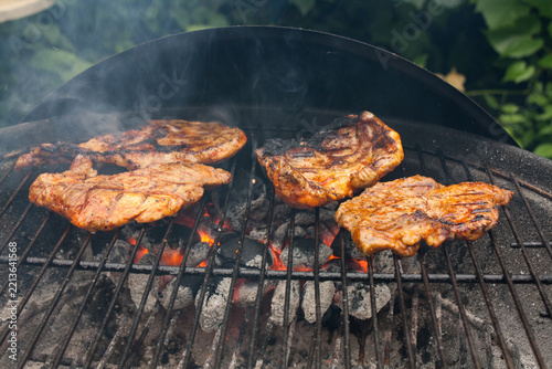 Grilling a juicy steak in the flames of a coal barbecue