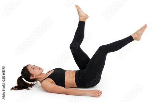 Athletic Woman Performing Bicycle Leg Exercise Isolated on White Background for Core and Abdominal Fitness Training