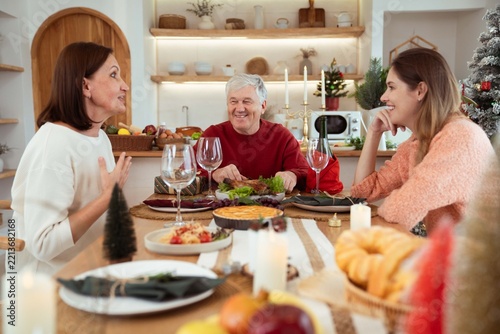 Happy family having Christmas dinner together at home kitchen