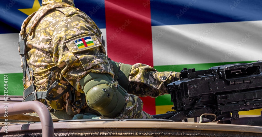 Fototapeta premium Central African Republic flag with soldier at machine gun turret in front of it. Closeup side view.