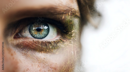A close-up of a blue-green eye with textured skin and natural light reflections, showcasing intricate details and a contemplative mood.