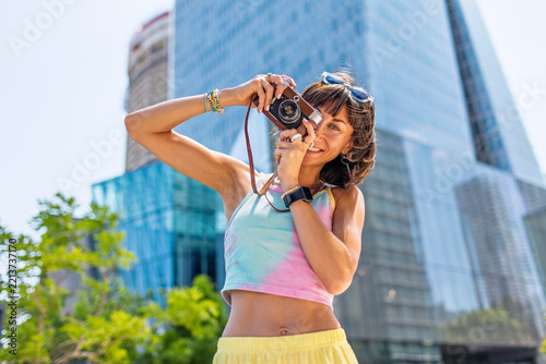 girl taking photo. Summer outdoor lifestyle, portrait of young beautiful woman having fun and enjoying vacation, traveling with camera.