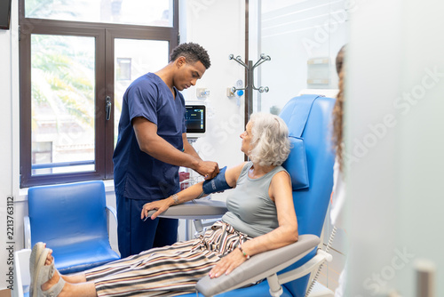 Healthcare professional checking blood pressure of senior patient