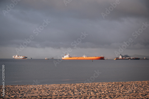 Cargo ship fleet offshore Gibraltar beneath storm clouds