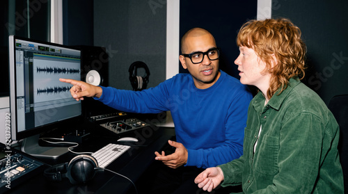 Audio producer explain waveform to podcast host in studio