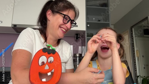 Mother and daughter create Halloween pumpkin with play dough