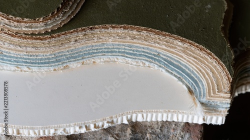 Topographic background texture made of layered cardboard waves, featuring rough corrugated edges and muted olive tones for cartography and map design