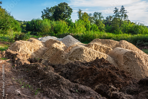 Fotografie Large mounds of sand and gravel piled up for walking path construction work in a