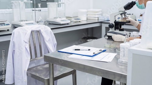 Food Safety Standards, A lab coat and clipboard on a table symbolize food safety rigor