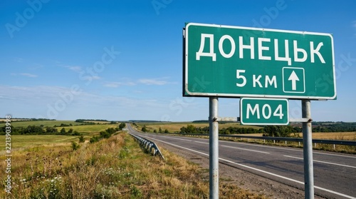 Donetsk city sign Ukraine road sign pointing to Donetsk 5 km M04 highway rural landscape