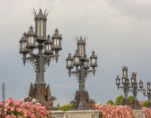 Wrought‑iron lanterns decorated with sculptures of griffins.