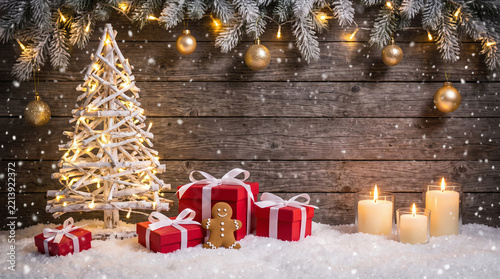 Christmas background with gifts and lights over rustic wooden wall