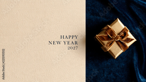 Minimal luxury composition featuring a golden gift box on a dark blue background with studio lighting