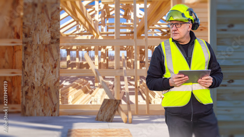 Construction site, building inspector uses a tablet to supervise timber house framing, structural work, safety compliance and contractor operations.