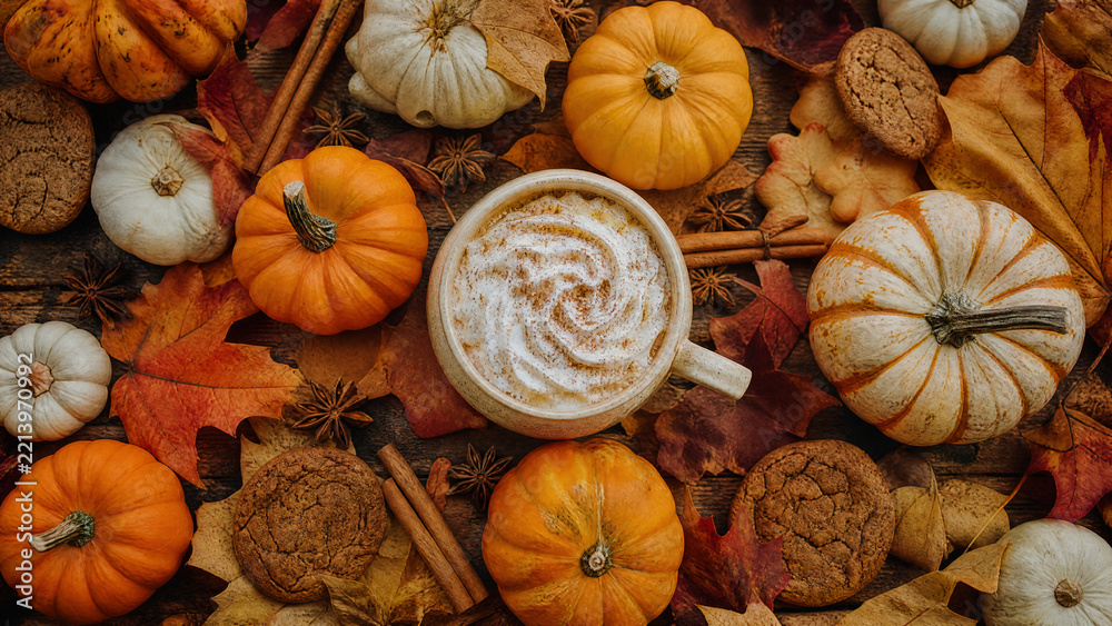 Naklejka premium Pumpkin spice latte with cinnamon and autumn leaves flat lay