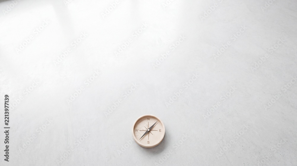 Fototapeta premium Minimalist wooden compass placed on a vast white surface with plenty of copy space for text, symbolizing guidance, strategic direction, core business concepts, navigation, and decision making.