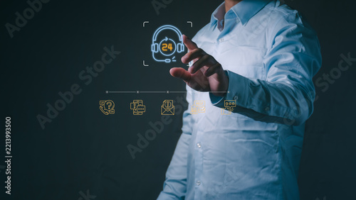 Businessman touches virtual headset for twenty four hour customer service, technical support, call center assistance, and omnichannel communication in the workspace.