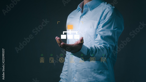 A businessman holds virtual corporate hierarchy chart for organizational structure, company leadership, team management, and workflow planning in office workspace.