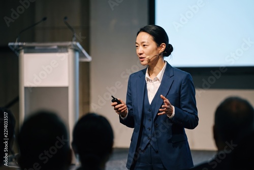 Generative AI, Asian businesswoman giving keynote speech on stage to audience