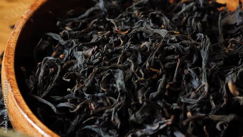 Dried black tea leaves in a wooden bowl	