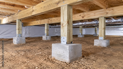 Interior Of A Residential Crawl Space With Concrete Footings And Wooden Floor Support, Underneath A Modern Home Construction