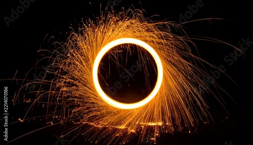 Abstract golden glowing portal ring with kinetic fire sparks and dust particles on isolated dark background texture