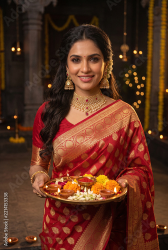 Happy Indian woman holding Traditional Diya puja thali During Diwali Festival 