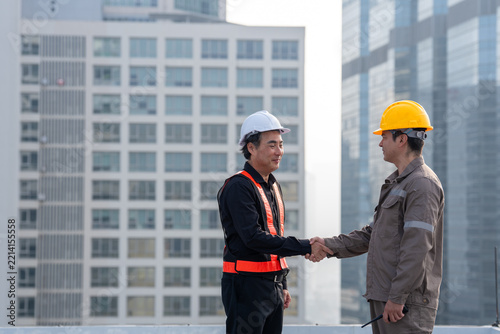 Construction worker industrial worker handshake safety helmet business agreement construction site, Professional construction worker handshake symbolizes teamwork and business agreement near