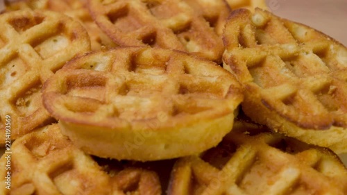 Rotating pile of golden-brown waffle cookies on a turntable, close-up shot showing crispy texture