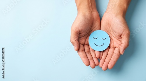 Peaceful blue smiley face held in hands, mental health and wellness concept, emotional support and psychological wellbeing for healthcare marketing