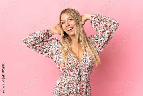 Young blonde woman isolated on pink background laughing
