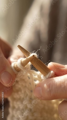 Close Up of Hands Knitting with Wool Yarn and Wooden Needles for Cozy Craft Project at Home