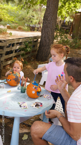 Family painting pumpkins celebrating halloween outdoors