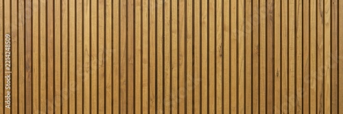 Modern vertical wooden slat wall texture, natural oak timber paneling background, ribbed brown wood batten surface for interior design and architecture