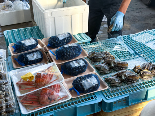 漁港の朝市で販売されるアワビやカニなど新鮮な海の幸