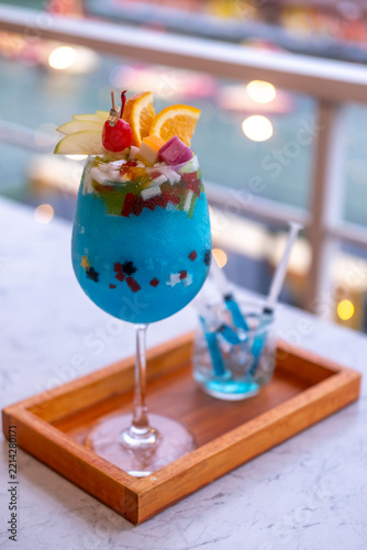 Blue Hawaii cocktail glass positioned with a distant sea and ocean horizon line background.
