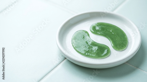 Green hydrogel eye patches on a white ceramic plate