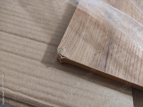 Close up of damaged chipboard corner with chipped edge and wood pattern on cardboard