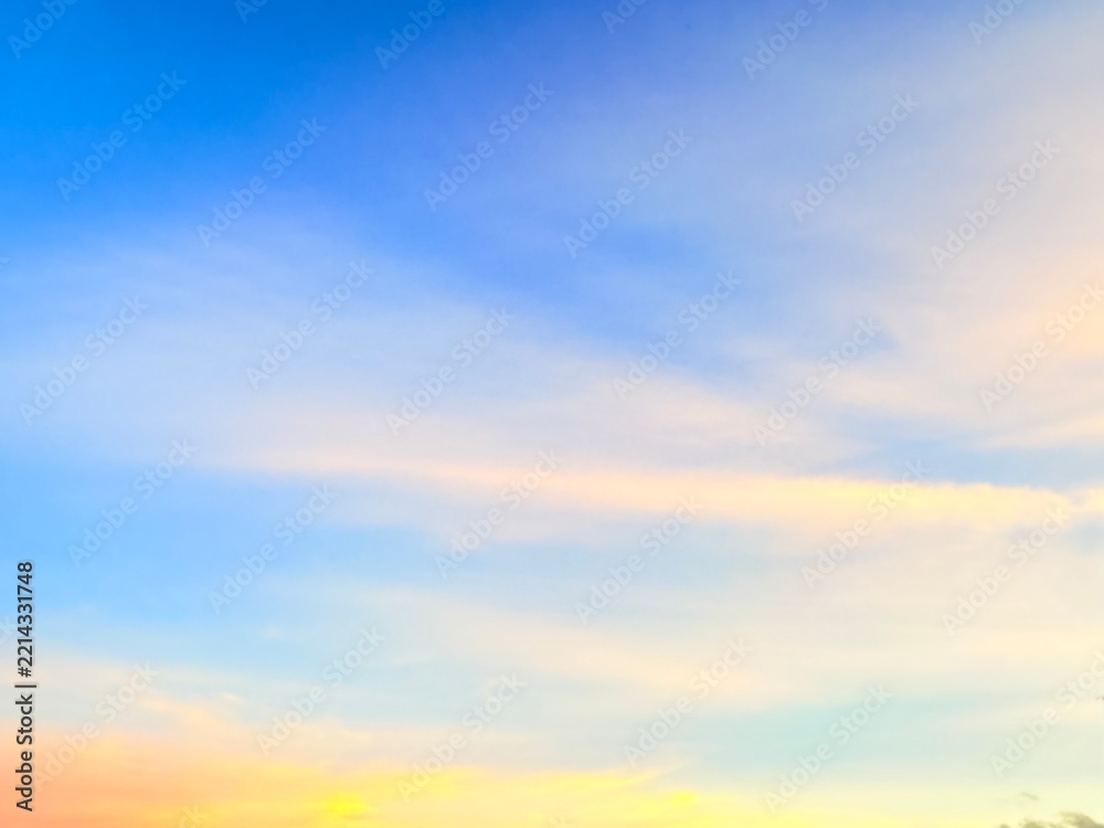 Naklejka premium Bright Blue Sky with Soft Golden Pastel Clouds at Sunset