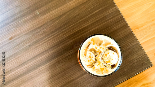 Fotografie Top view of a refreshing iced coffee drink on a wooden table