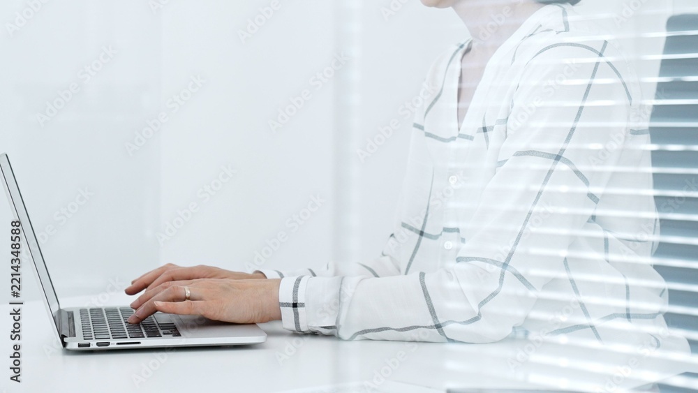 Fototapeta premium Business person working remotely or in a modern office. Typing on a laptop keyboard. Focusing on digital tasks. Achieving productivity and professional goals
