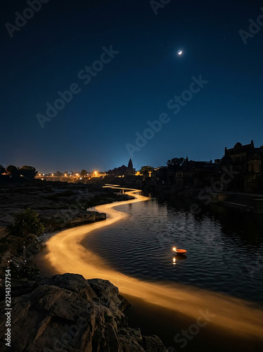 Nighttime river scene with illuminated boat during evening twilight