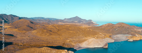 Rocky seashore with clear blue sky. Seascape in the evening. Cabo de Gata-Níjar reserve. Almeria Andalusia Spain
