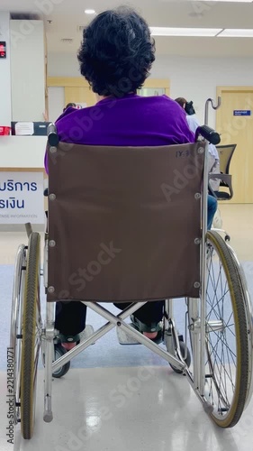 Elderly woman sitting in a wheelchair inside a hospital, viewed from behind, representing healthcare, mobility, accessibility, patient care, medical services, and assisted living.