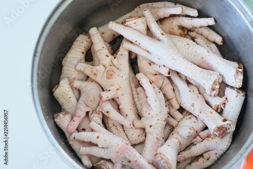 Raw seasoned chicken feet stacked inside a metal pot