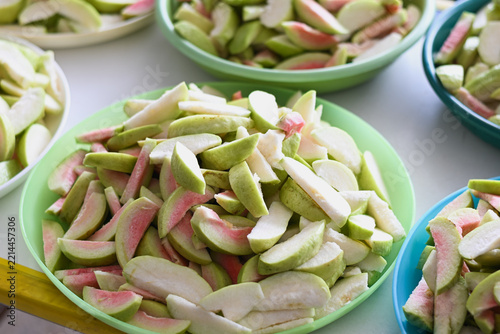 Sliced fresh pink-fleshed guava served on white plates